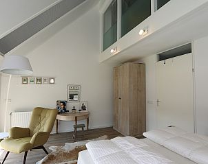 Slaapkamer met comfortabele stoelen in Vakantiehuis Duinhuis 11, Noordwelle, Schouwen-Duiveland, perfect voor ontspanning.