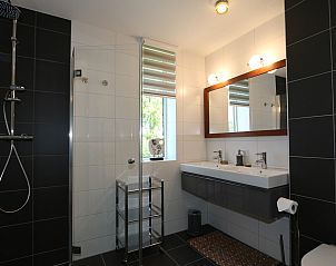 Luxe badkamer met dubbele wastafel in Vakantiehuis Duinhuis 11, Noordwelle, Schouwen-Duiveland, voorzien van moderne voorzieningen.