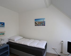 Eenvoudige en moderne slaapkamer in Vakantiehuis Duinhuis 11, Noordwelle, Schouwen-Duiveland, met eenpersoonsbed.