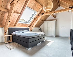 Slaapkamer met houten balken in Vakantiehuis in Noordwelle, Zeeland.