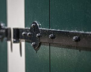 Exterieur met groene luiken in Vakantiehuis in Noordwelle, Zeeland.