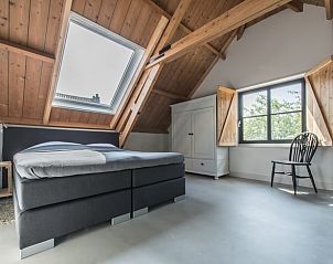 Slaapkamer met houten dak in Vakantiehuisje in Noordwelle, knusse sfeer in Schouwen-Duiveland, Zeeland.