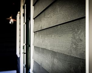 Buitenkant van Vakantiehuisje in Noordwelle met houten gevelbekleding, Schouwen-Duiveland, Zeeland.