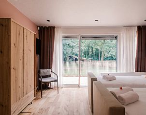 Slaapkamer met uitzicht op tuin in Vakantiehuis in Noordwelle, Schouwen-Duiveland, Zeeland.