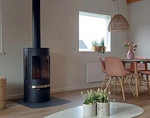 Eetkamer met houtkachel in Vakantiehuis in Noordgouwe, ideaal voor sfeervolle avonden in Zeeland.