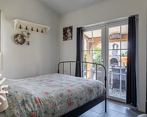 Loungehoek op terras van vakantiehuis ZE1221 in Sint-Annaland, Tholen met parasol.