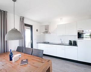 Eetgedeelte en keuken in Vakantiehuis Oesterdam Resort in Tholen, Zeeland met houten tafel.