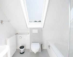 Moderne badkamer met ligbad in Vakantiehuis Oesterdam Resort in Tholen, Zeeland.