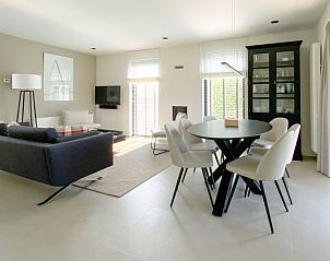 Ruime woonkamer met grote ramen in Vakantiehuis Oesterdam Resort in Tholen, Zeeland.