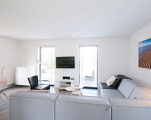 Moderne zithoek met televisie in Vakantiehuis Oesterdam Resort in Tholen, Zeeland.