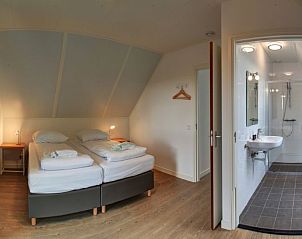 Gezellige slaapkamer met en-suite badkamer in Vakantiehuis Oesterdam Resort, Tholen, Zeeland voor optimaal comfort.