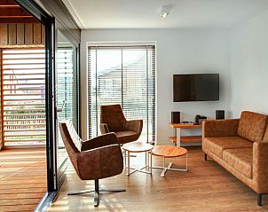 Lichte woonkamer in Vakantiehuis Oesterdam Resort, Tholen, Zeeland met toegang tot het terras.