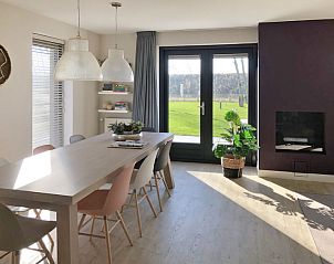 Eetkamer in Vakantiehuis Oesterdam Resort, Tholen, Zeeland met uitzicht op de tuin en veel lichtinval.