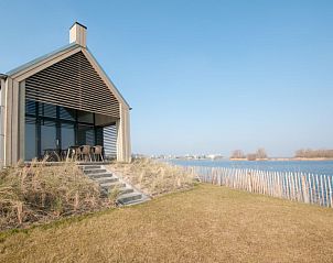 Vakantiehuis Oesterdam Resort in Tholen, Zeeland met uitzicht op het water en een moderne veranda.