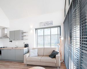 Gezellige zithoek in Vakantiehuis Oesterdam Resort in Tholen, Zeeland met grote ramen.