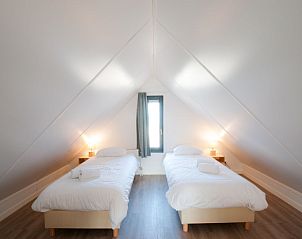 Zolderkamer met twee eenpersoonsbedden in Vakantiehuis Oesterdam Resort, Tholen, Zeeland.