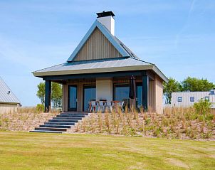 Vakantiehuis met veranda bij Oesterdam Resort in Tholen, Zeeland, omgeven door groene natuur.