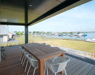 Ruim terras met uitzicht op de jachthaven bij Vakantiehuis Oesterdam Resort, Tholen, Zeeland.