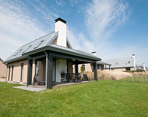 Vakantiehuis met overdekt terras bij Oesterdam Resort in Tholen, omgeven door groene velden.