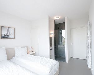 Lichte slaapkamer met ensuite badkamer in Vakantiehuis Oesterdam Resort, Tholen, perfect voor comfort.