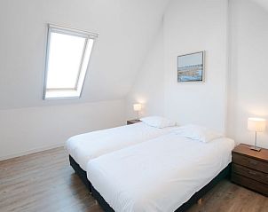 Lichte tweepersoonsslaapkamer in Vakantiehuis Oesterdam Resort, Tholen, met dakraam en houten vloer.