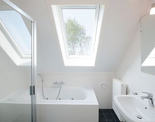 Luxe badkamer in Vakantiehuis Oesterdam Resort, Tholen, met ligbad en dakramen.