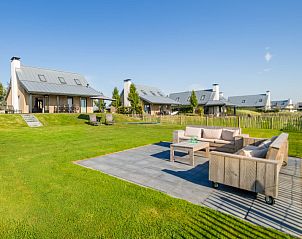 Buitenterras van Vakantiehuis Oesterdam Resort, Tholen, met comfortabele zitgelegenheid.