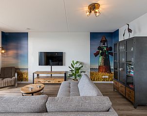 Stijlvolle woonkamer in Appartement in Scherpenisse, Tholen, Zeeland met moderne inrichting en kunst aan de muur.