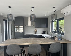 Moderne keuken van VZ1111 Vakantiechalet in Scherpenisse, Tholen, Zeeland met bar en design krukken.