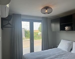 Hoofdslaapkamer in VZ1111 Vakantiechalet in Scherpenisse, Tholen, Zeeland met uitzicht op de tuin.