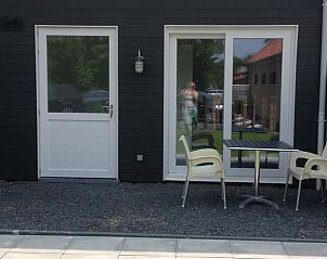 Terras bij Vakantiehuisje in Koudekerke, Walcheren, met zitgelegenheid en uitzicht op de tuin.