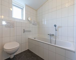 Modernes Badezimmer im Ferienhaus 'T Bloemenhof Koudekerke mit weien Fliesen und Badewanne, Walcheren, Zeeland.