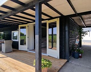 Veranda des Cottage in Koudekerke, Ferienhaus auf Walcheren, Zeeland, mit Blick ins Grne und gemtlicher Sitzecke.