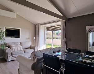 Gemtliches Wohnzimmer des Ferienhauses in Koudekerke, Walcheren, Zeeland mit bequemer Sitzecke und Blick auf die grne Umgebung.