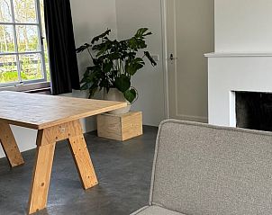 Stijlvolle binnenruimte van Vakantiehuis in Koudekerke, Walcheren, met houten tafel en groene planten in een serene omgeving.