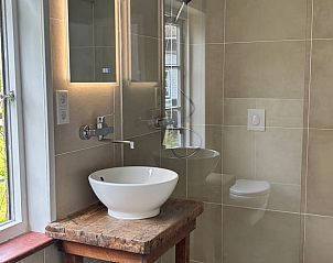 Stijlvolle badkamer in Vakantiehuis in Koudekerke, Walcheren, Zeeland met modern wastafelmeubel en uitzicht op de groene omgeving.