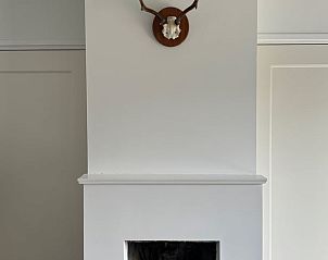 Gezellige woonkamer van Vakantiehuis in Koudekerke met rustieke open haard, ideaal voor ontspannen verblijf in Walcheren, Zeeland.