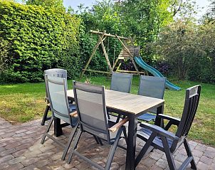 Garden with dining table and playground equipment at VZ2330 Holiday home in Oostkapelle, Walcheren, Zeeland.