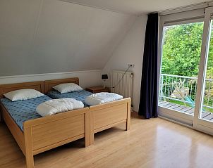 Bedroom with balcony and garden view in VZ2330 Holiday home Oostkapelle, Walcheren, Zeeland.