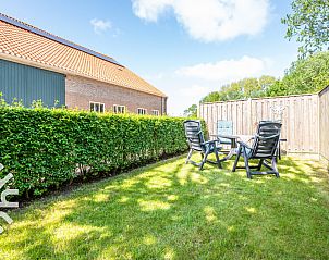 Dining area with wooden table and kitchen in vacation home ZE118, Oostkapelle, Walcheren, Zeeland.