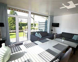 Lichte woonkamer in VZ986 Vakantiebungalow in Oostkapelle met uitzicht op de tuin in Walcheren, Zeeland.