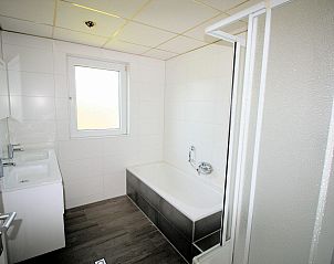 Ruime badkamer van VZ986 Vakantiebungalow in Oostkapelle met bad en douche in Walcheren, Zeeland.