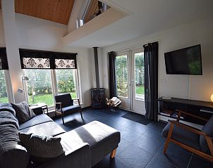 Moderne woonkamer van VZ1174 Vakantiehuis in Oostkapelle met uitzicht op de tuin.