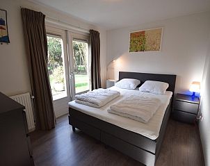 Slaapkamer in VZ1174 Vakantiehuis in Oostkapelle met toegang tot de tuin.