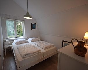 Schlafzimmer mit Doppelbett im Ferienhaus VZ1158 in Oostkapelle, Walcheren, mit Fenster und Aussicht.