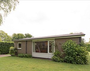 Voorzijde van VZ1182 Vakantiebungalow in Oostkapelle, Walcheren, omgeven door groen.