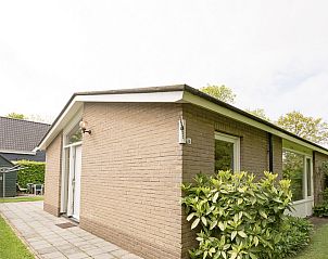Achterzijde van VZ1182 Vakantiebungalow in Oostkapelle, Walcheren, met groene heg.
