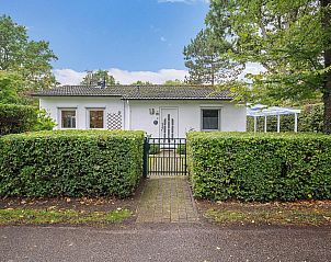 Front view of VZ2420 Holiday bungalow Oostkapelle surrounded by greenery in Walcheren