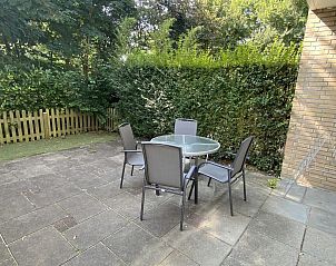 Terras van VZ069 Vakantieappartement Oostkapelle, Walcheren, omgeven door groen en privacy.