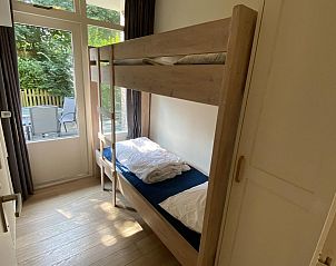 Slaapkamer met stapelbed in VZ069 Vakantieappartement Oostkapelle, Walcheren, met uitzicht op tuin.